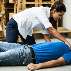 worker giving first aid to another worker